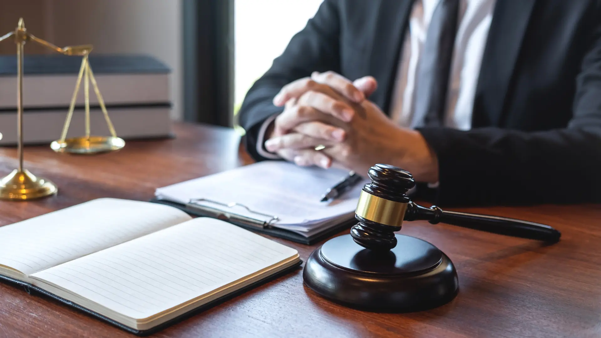 Lawyer in courtroom holding a gavel and notebook, preparing for a case presentation.