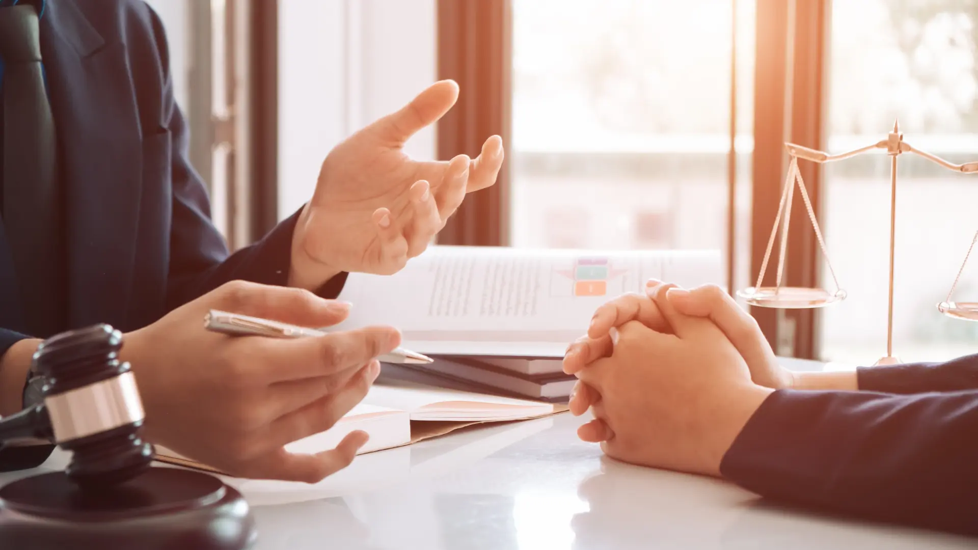 Close-up of two people having a discussion with documents on the table.